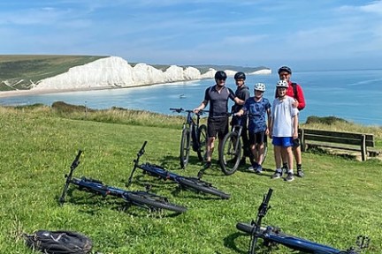a group of people standing around a motorcycle in a field