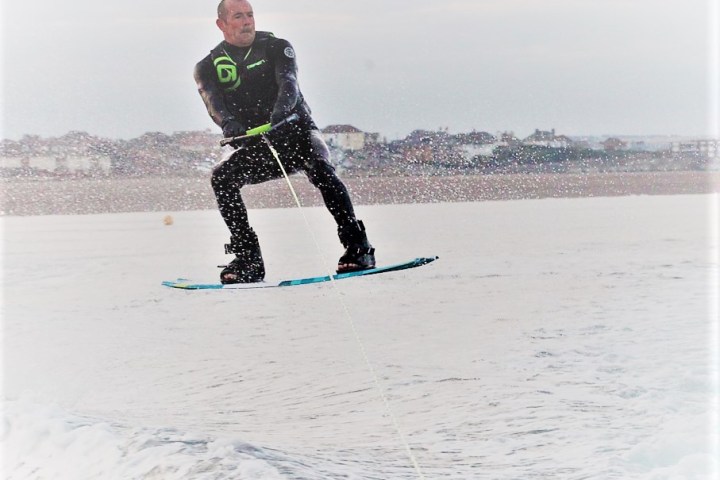 a man riding a snow board in the water