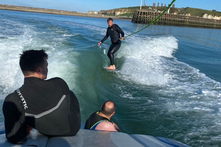 a man sitting next to a body of water