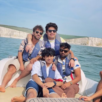 a group of people sitting next to a body of water
