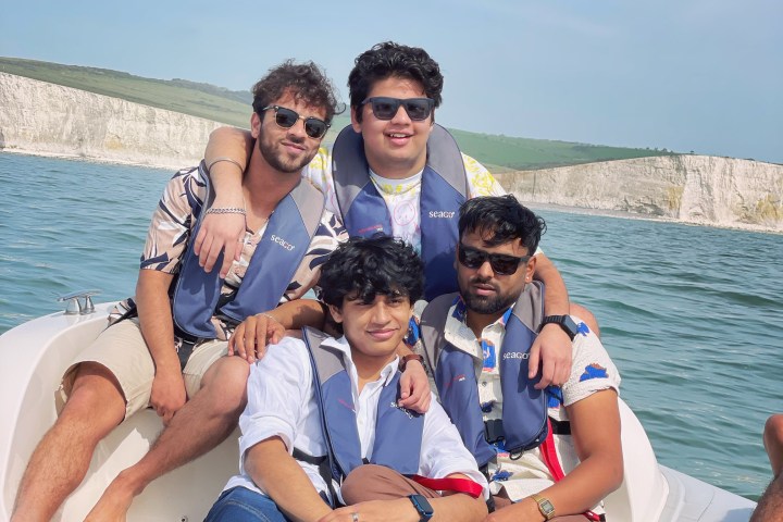 a group of people sitting next to a body of water