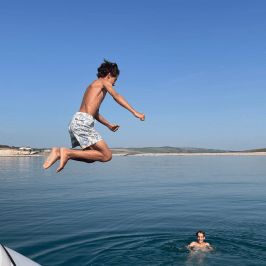 a man flying through the air over a body of water