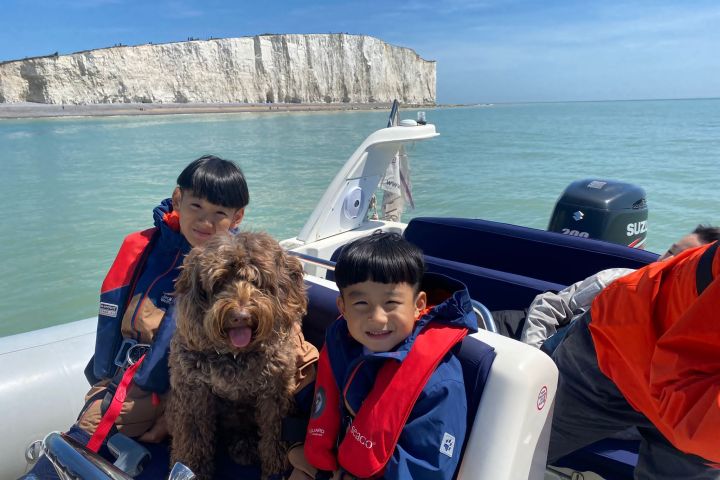 Seok-hyeon Hwang and a dog sitting in front of a body of water