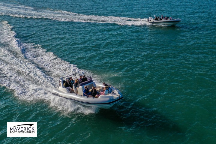 a man riding on the back of a boat in the water