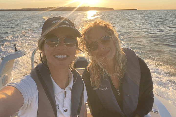 a woman sitting next to a body of water