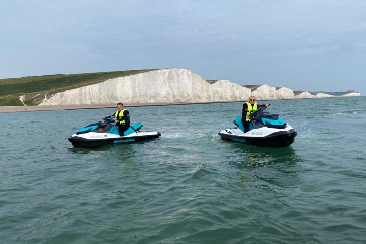 a group of people riding on the back of a boat in the water