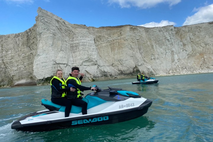 a group of people riding on the back of a boat in the water