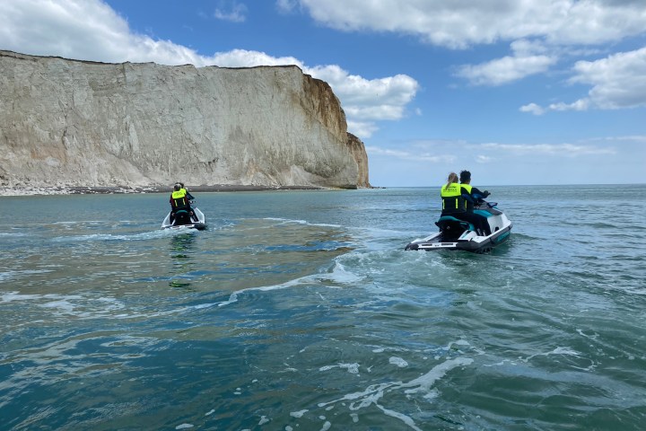 a group of people riding skis on a body of water