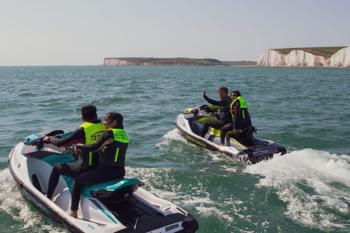 a group of people riding on the back of a boat in the water