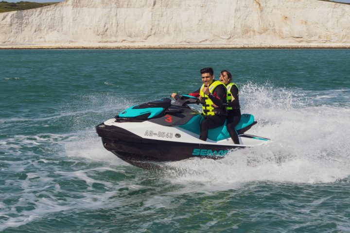 a man riding on the back of a boat in the water