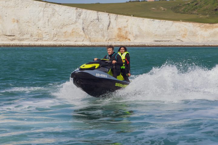 a man riding on the back of a boat in the water