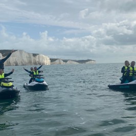 a group of people riding on the back of a boat in the water