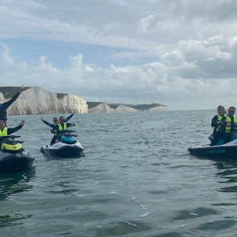 a group of people riding on the back of a boat in the water