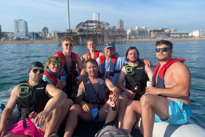 a group of people sitting on a bench next to a body of water