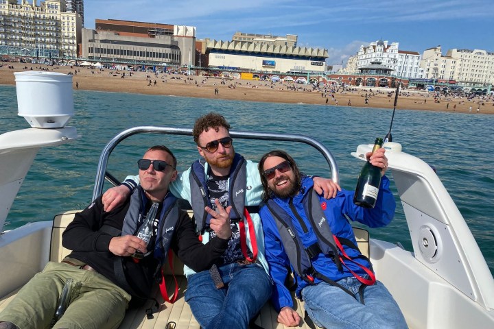 a group of people sitting on a boat posing for the camera