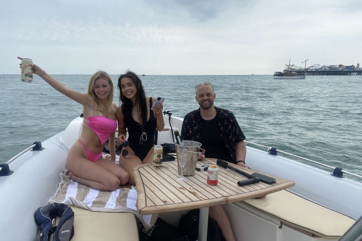 a woman sitting at a table with people in the water