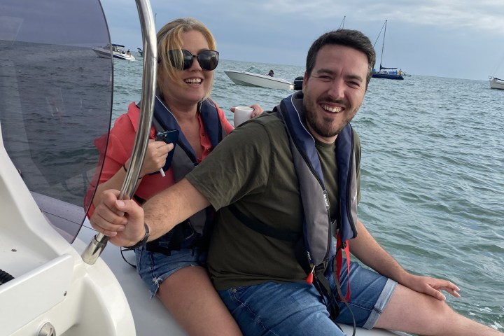 a man and a woman sitting on a boat in a body of water