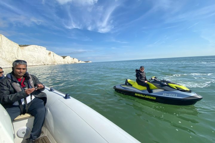a group of people riding on the back of a boat in the water