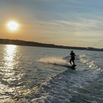 a man standing next to a body of water