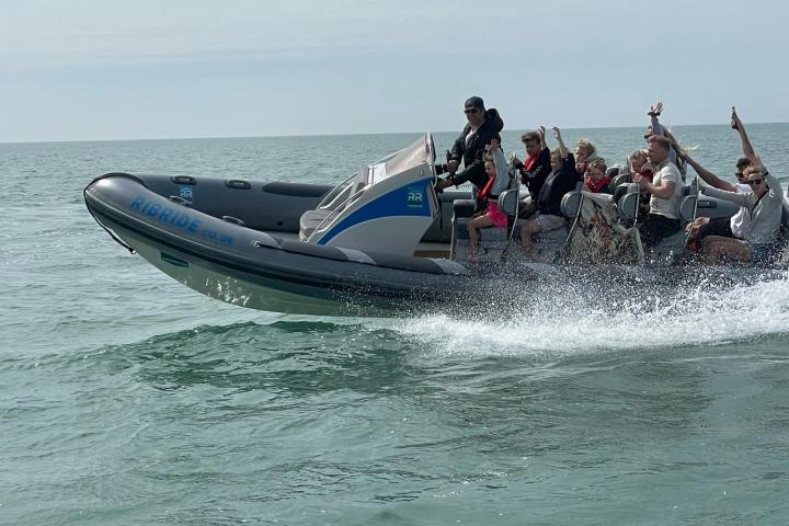 a group of people riding on the back of a boat in the water