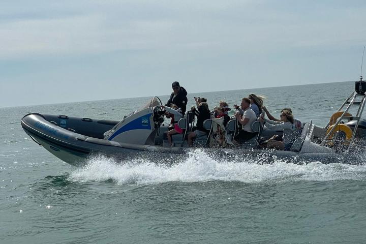 a group of people riding on the back of a boat in the water