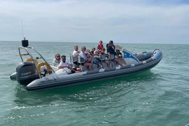 a group of people riding on the back of a boat in the water