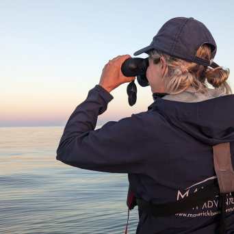 a man standing next to a body of water