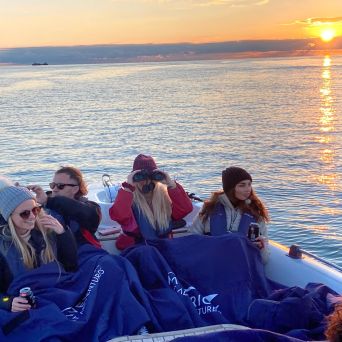 a group of people sitting in a boat on a body of water