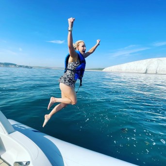 a woman standing next to a body of water