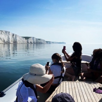 a group of people sitting next to a body of water