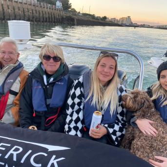 a group of people sitting next to a body of water