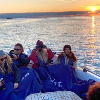 a group of people sitting next to a body of water