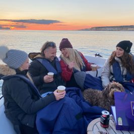 a group of people sitting next to a body of water