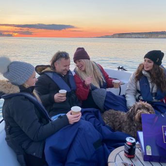 a group of people sitting next to a body of water